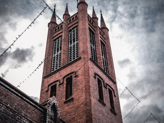 brown concrete building under white clouds during daytime in Palmerston North New Zealand