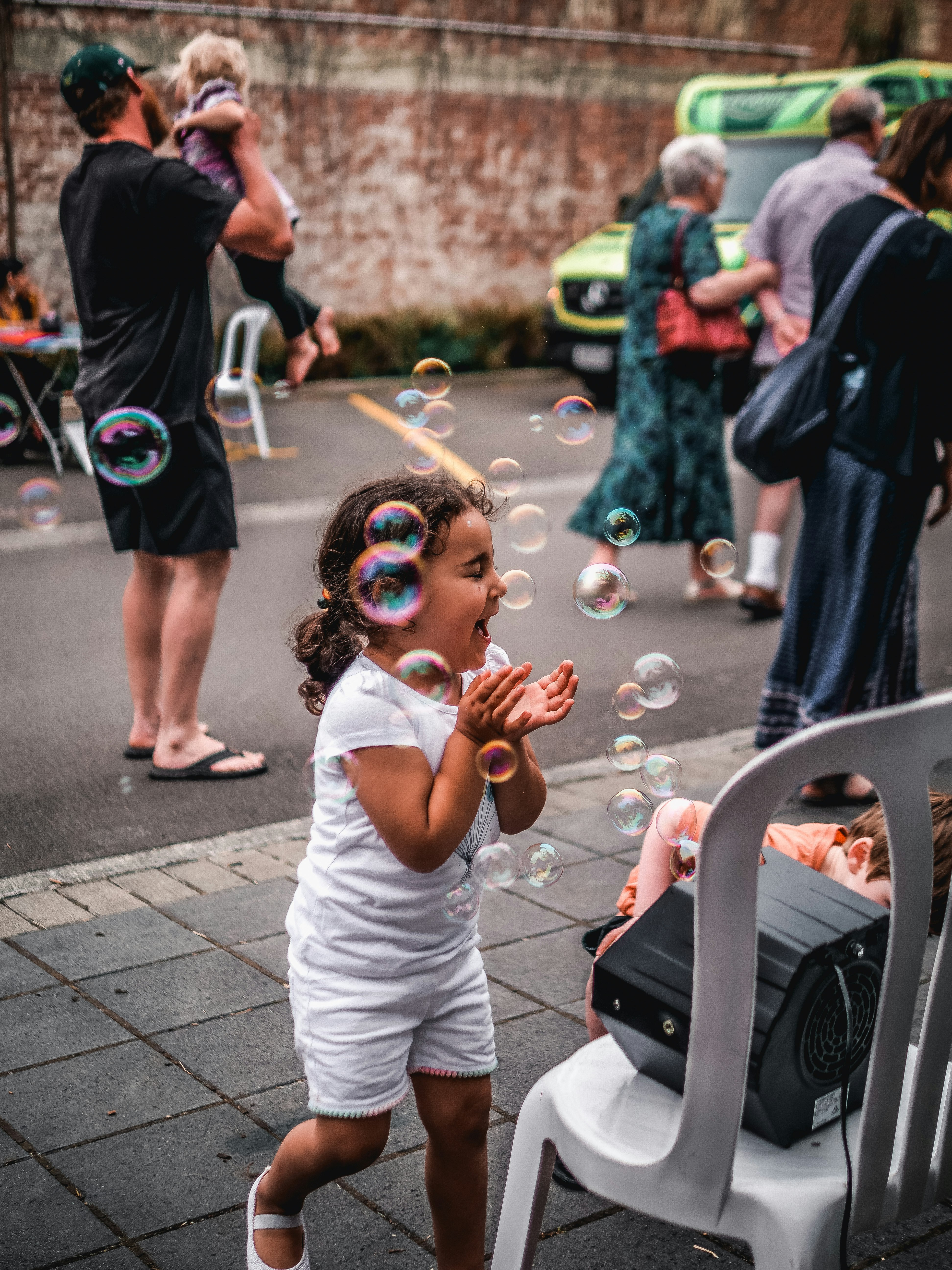 girl in white shirt playing bubbles