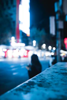 Evening cityscape blurred in background with a bold streetwear outfit in the foreground.
