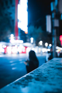 Evening cityscape blurred in background with a bold streetwear outfit in the foreground.