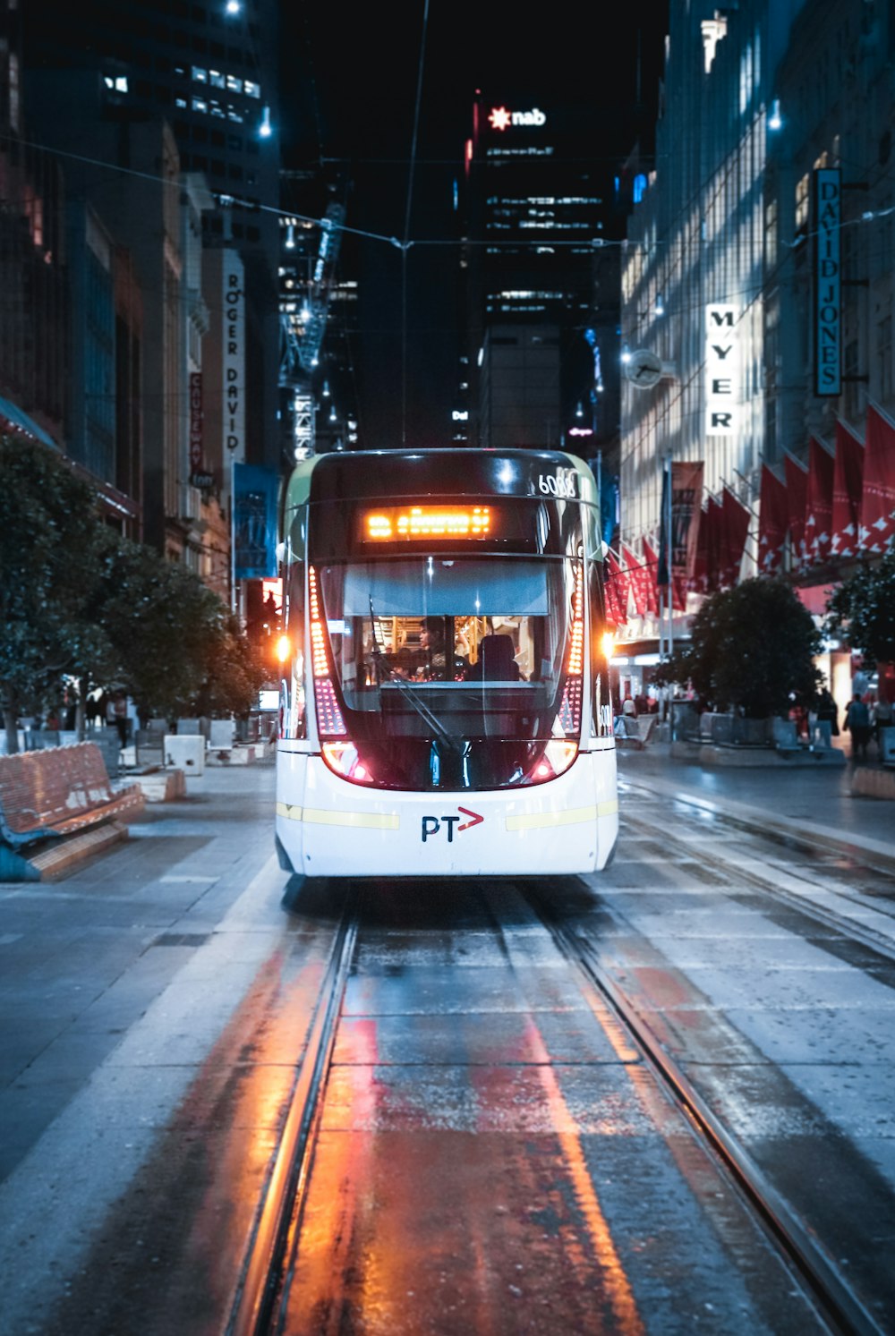 Tramway blanc et marron sur la route pendant la nuit