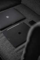 silver macbook on black textile