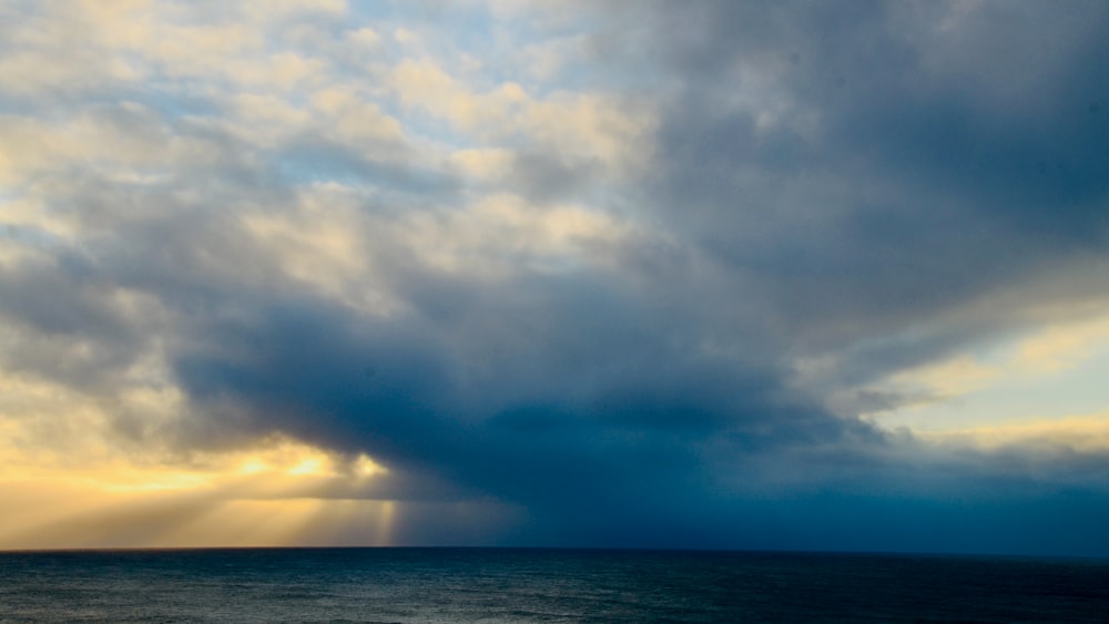 body of water under cloudy sky during daytime