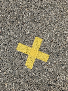 yellow arrow sign on gray concrete floor