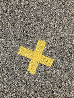 yellow arrow sign on gray concrete floor