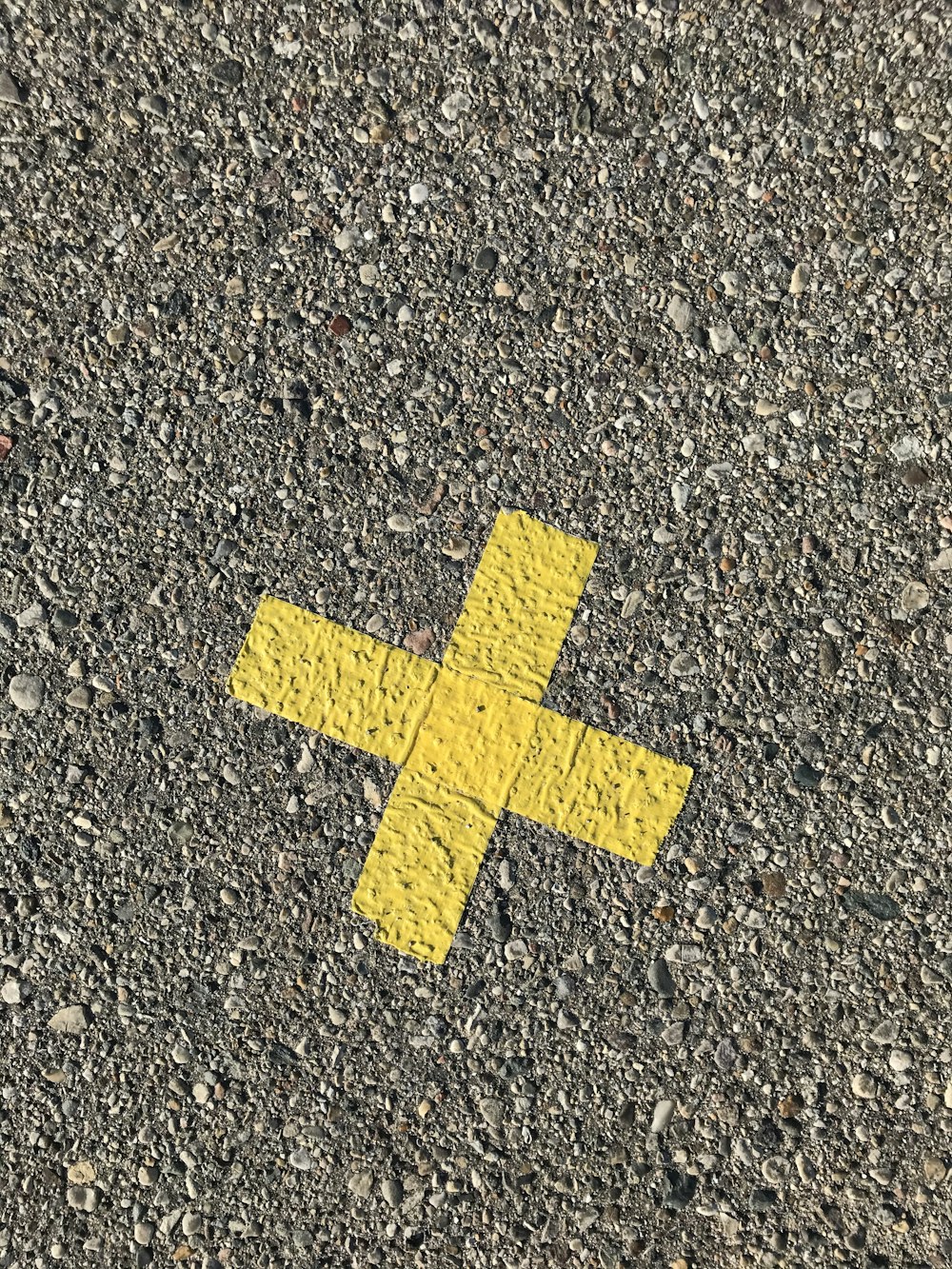 yellow arrow sign on gray concrete floor