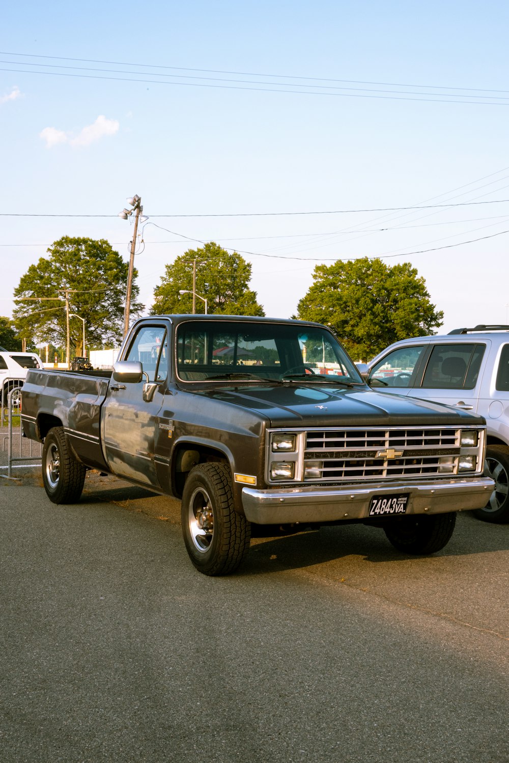 blue chevrolet single cab pickup truck parked on gray concrete road during daytime