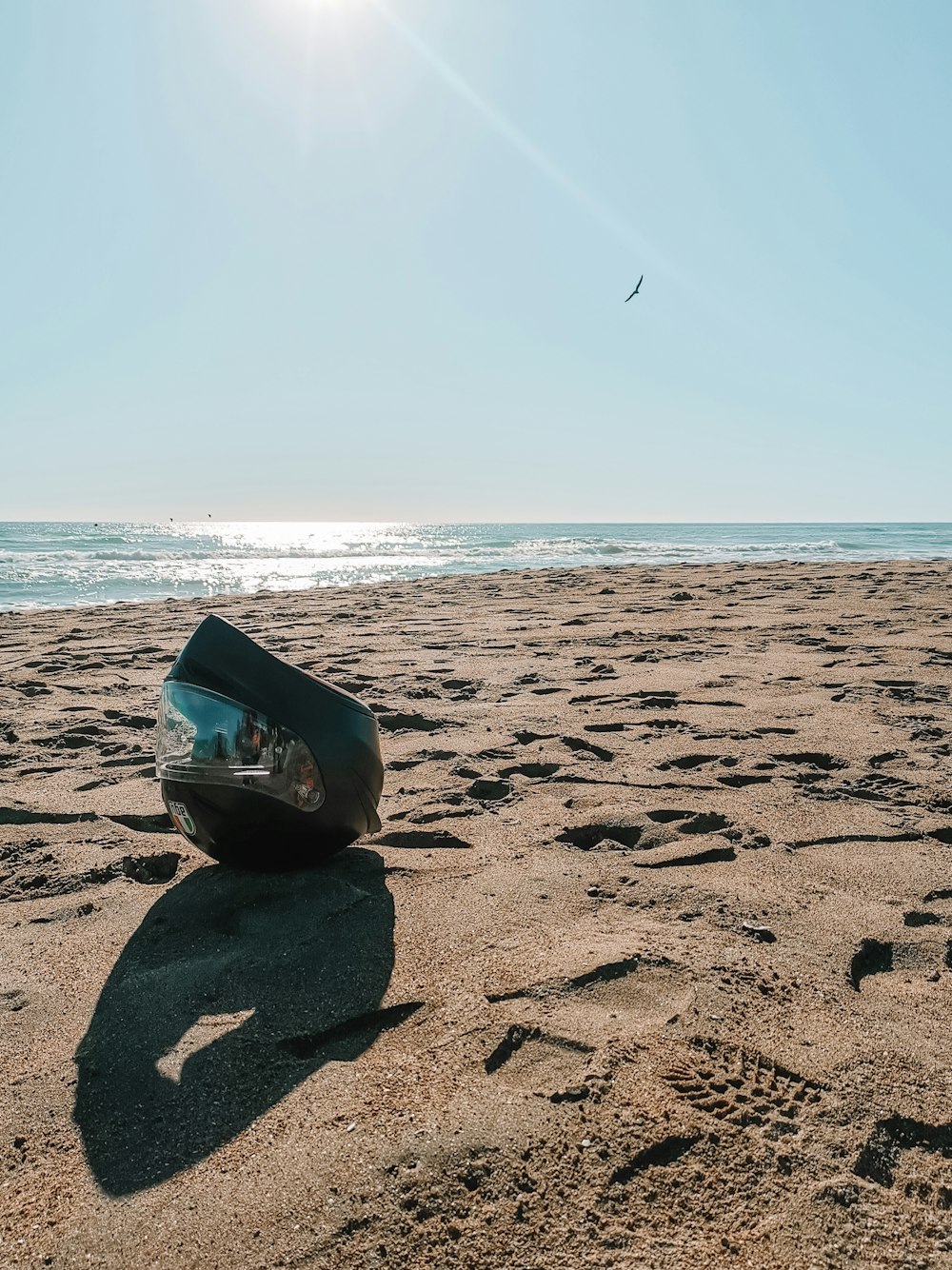 blue and white inflatable ring on brown sand near sea during daytime