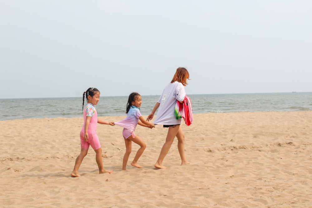 2 women walking on beach during daytime