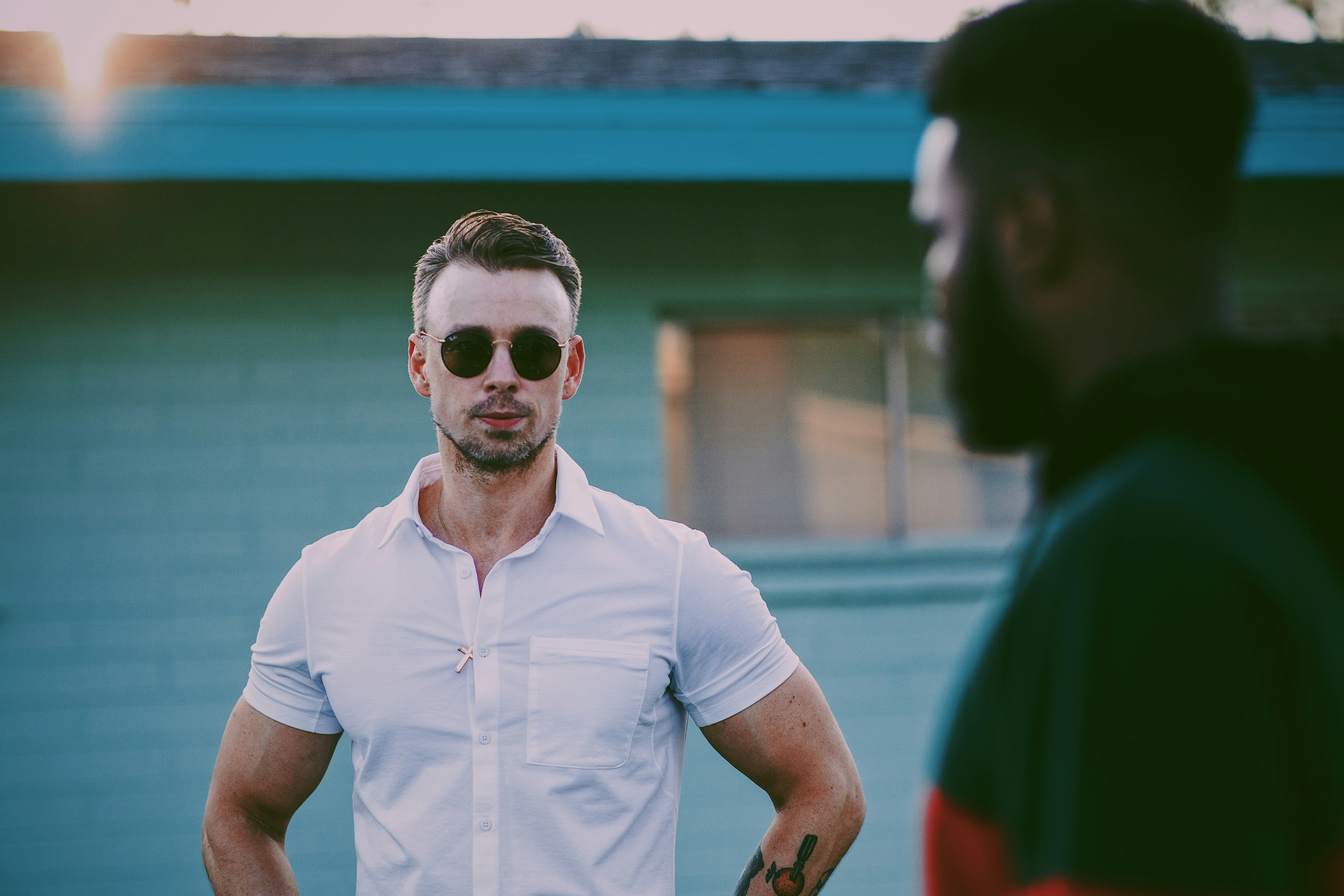 man in white polo shirt wearing black sunglasses