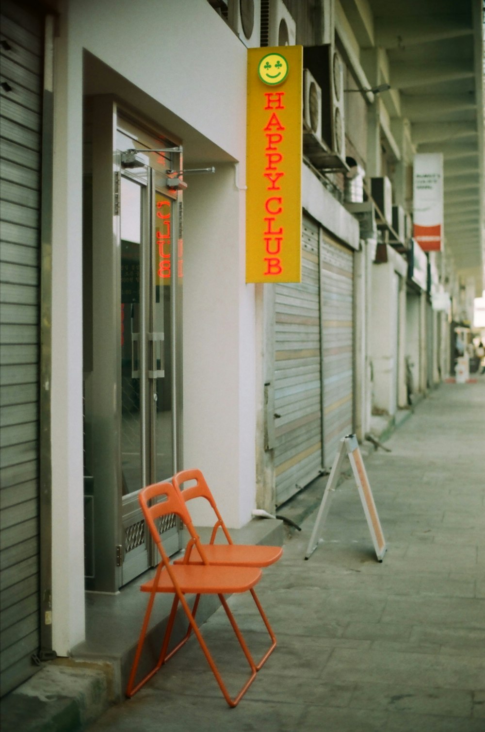 orange plastic armchair beside white wooden door