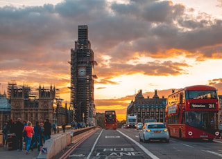 cars on road near buildings during sunset