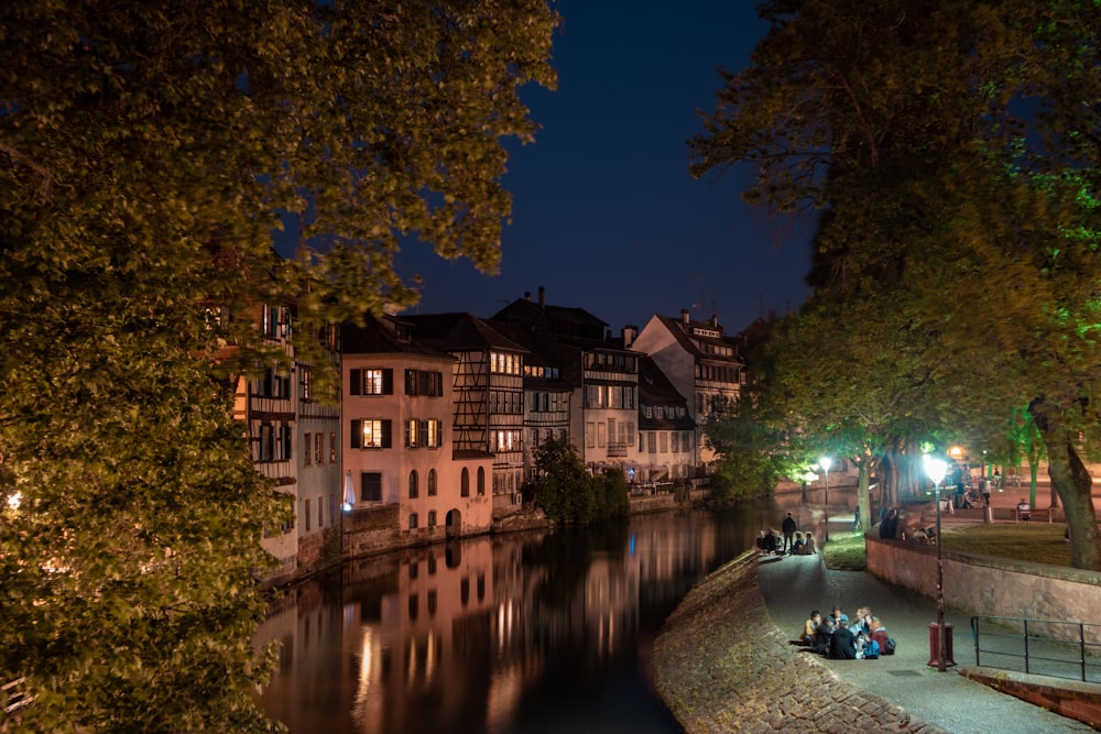 Braunes und weißes Betongebäude in der Nähe des Flusses während der Nachtzeit