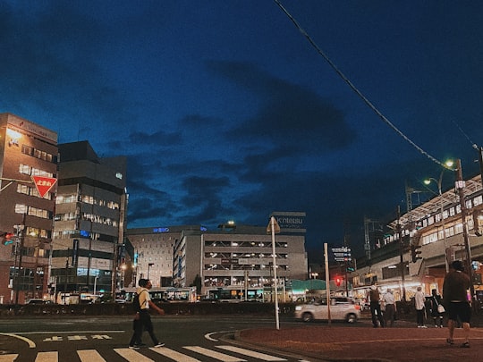 people walking on sidewalk near buildings during night time in Kintetsu-Yokkaichi Station Japan
