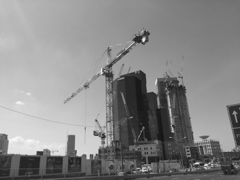 Construction site with cranes and urban skyline background.