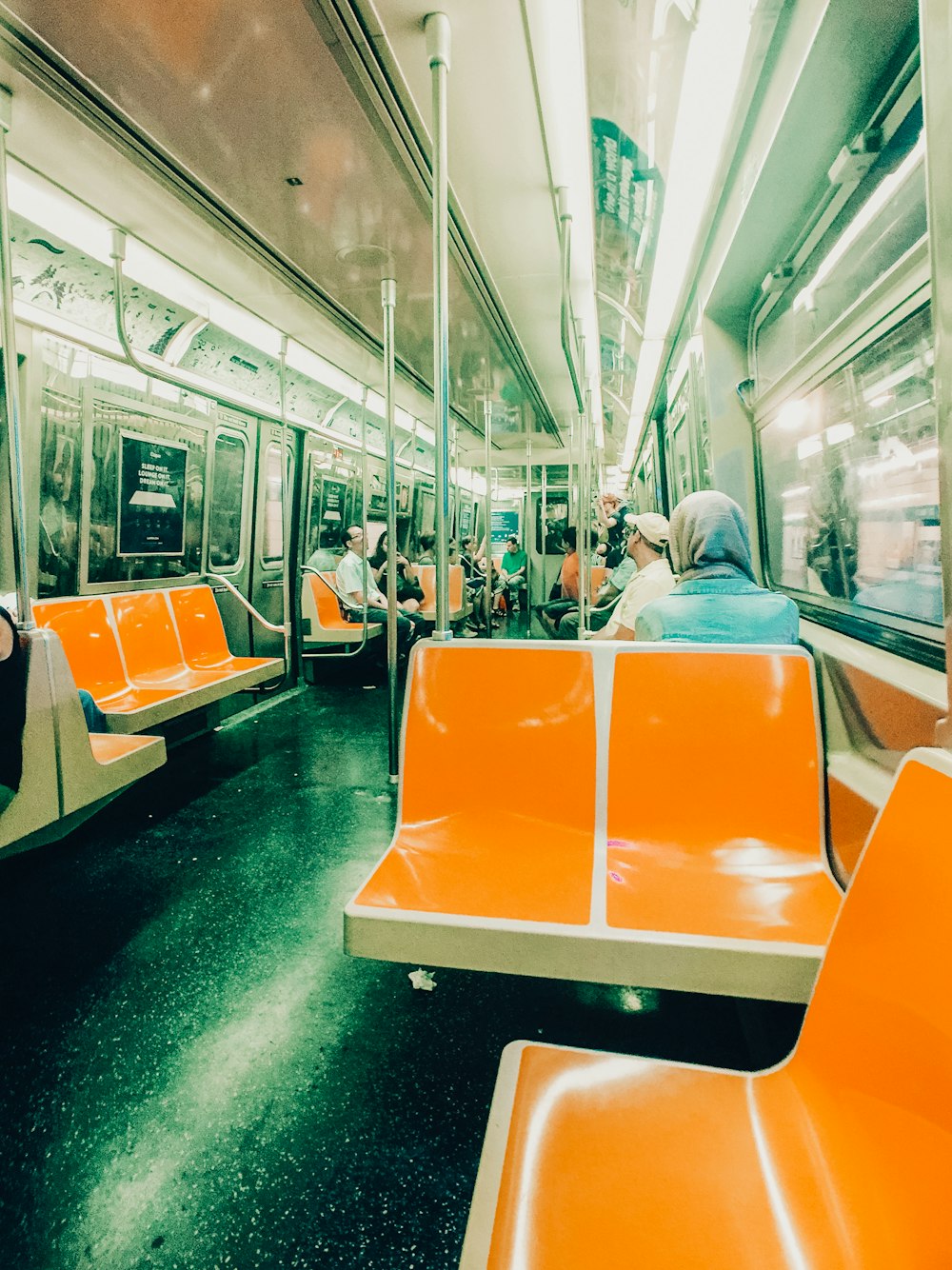 people sitting on orange and white train seat