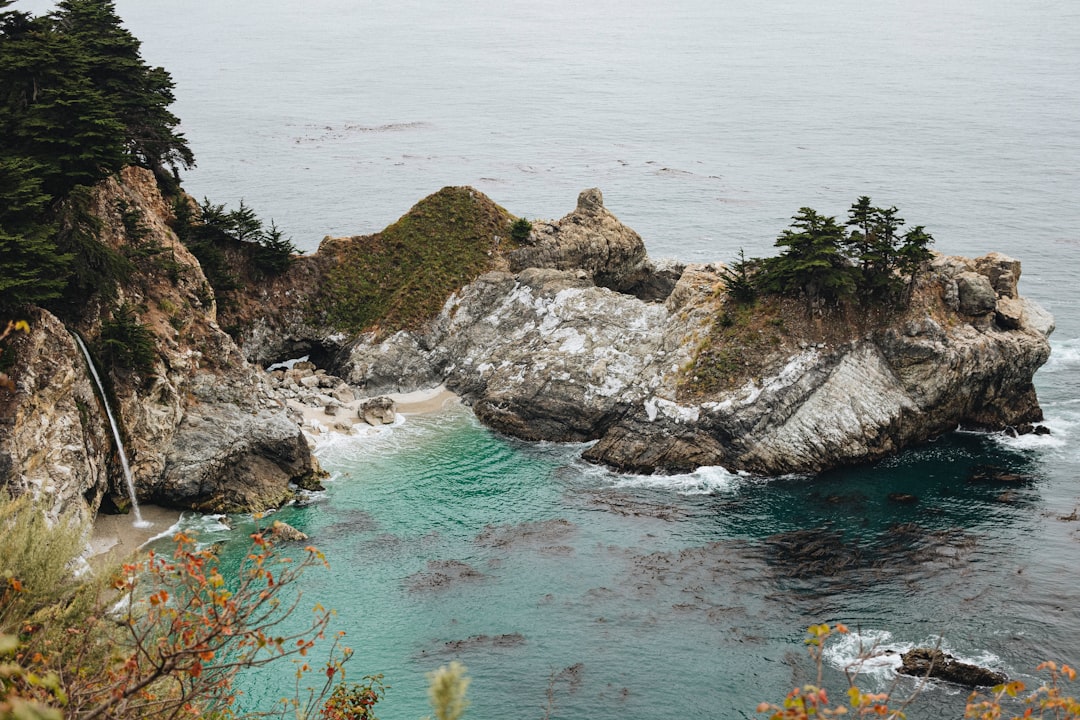 brown and green rock formation on blue sea water during daytime