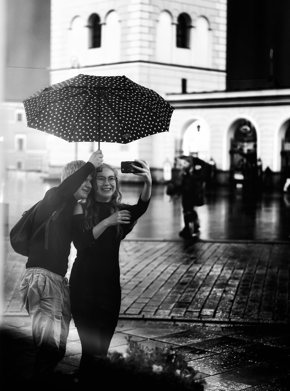 grayscale photo of woman in black dress holding umbrella