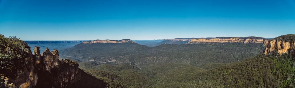 montagnes vertes et brunes sous le ciel bleu pendant la journée