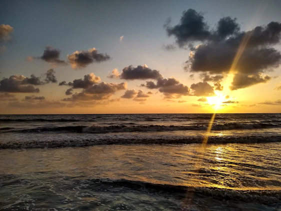 A serene beige and brown sunset with golden rays gently illuminating a music timer.