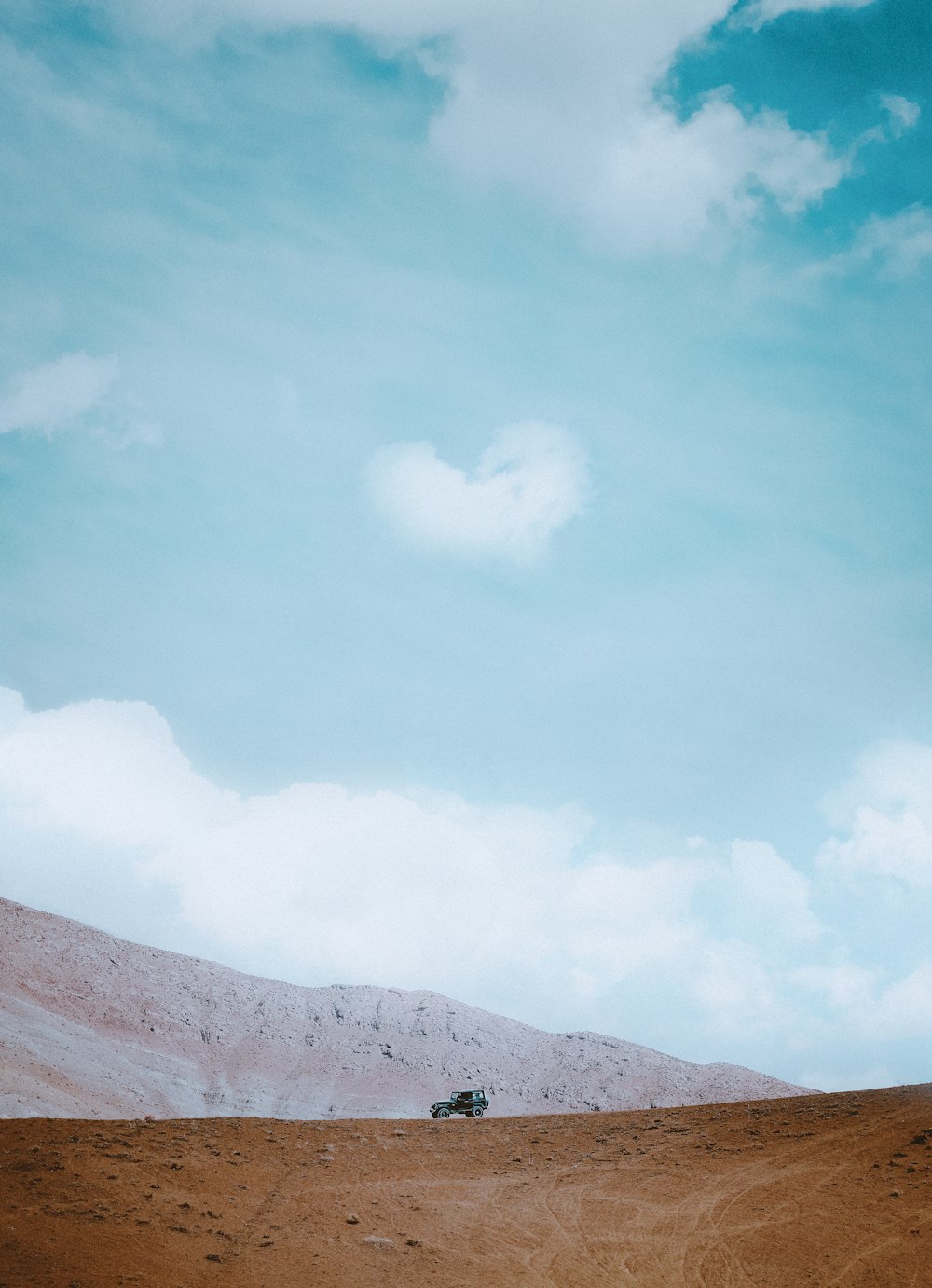 brown mountain under white clouds during daytime