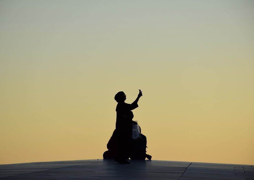 silhouette of woman sitting on floor during sunset