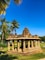 brown concrete temple near green trees during daytime