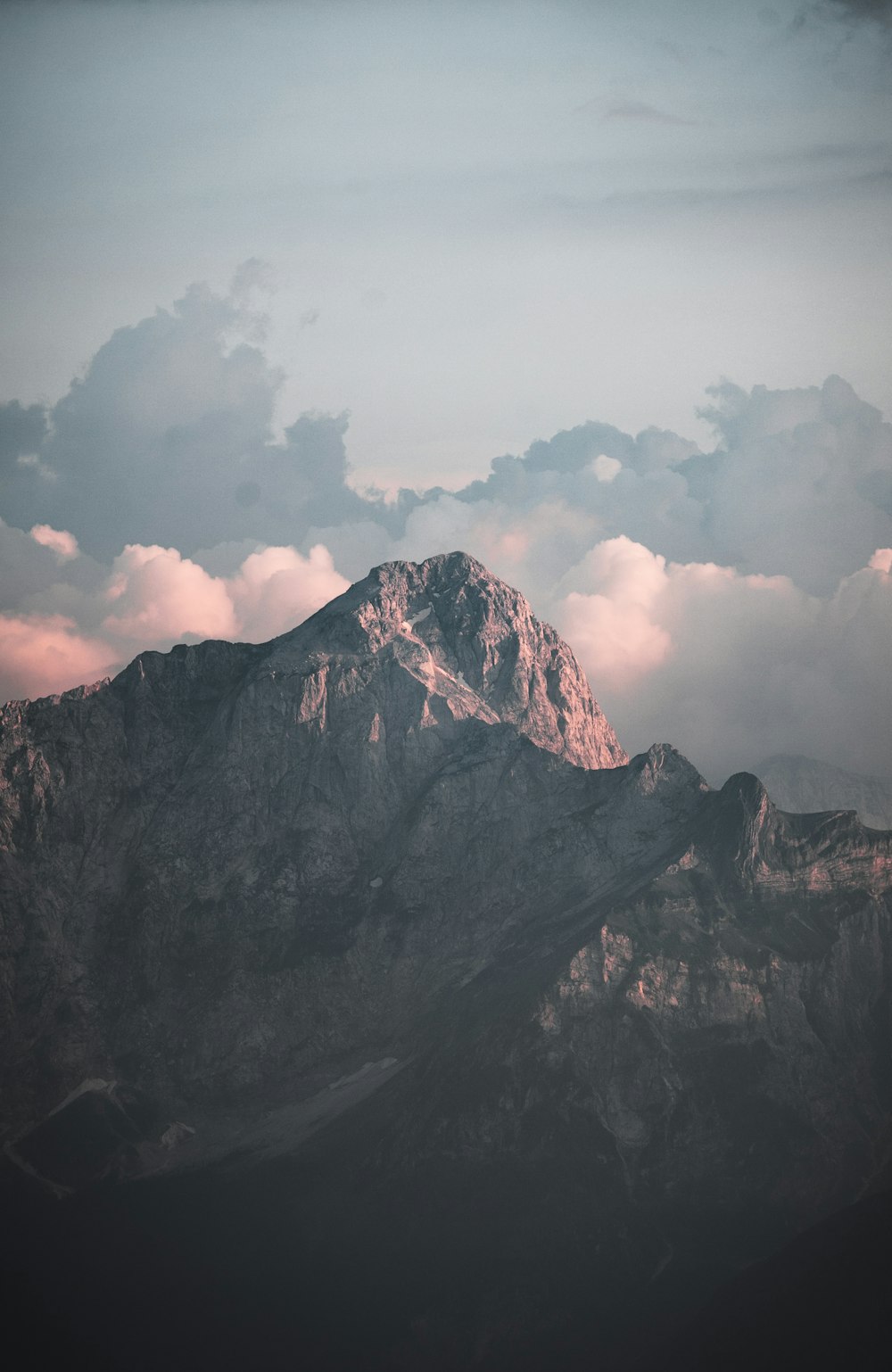 black and white mountain under white clouds