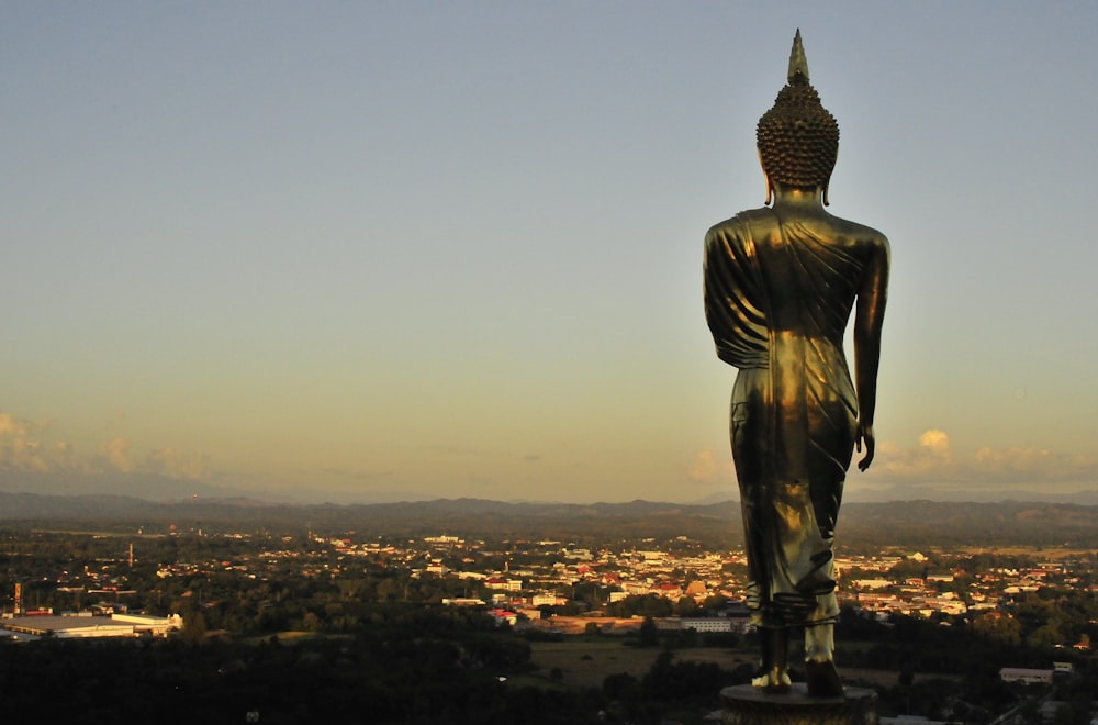 silhueta do homem em pé no topo do edifício durante o pôr do sol