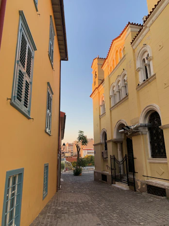 Historic cobblestone alleyway lined with charming old buildings bathed in golden afternoon light.