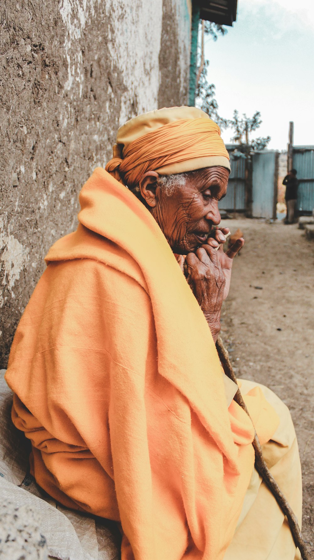 man in yellow hoodie leaning on wall