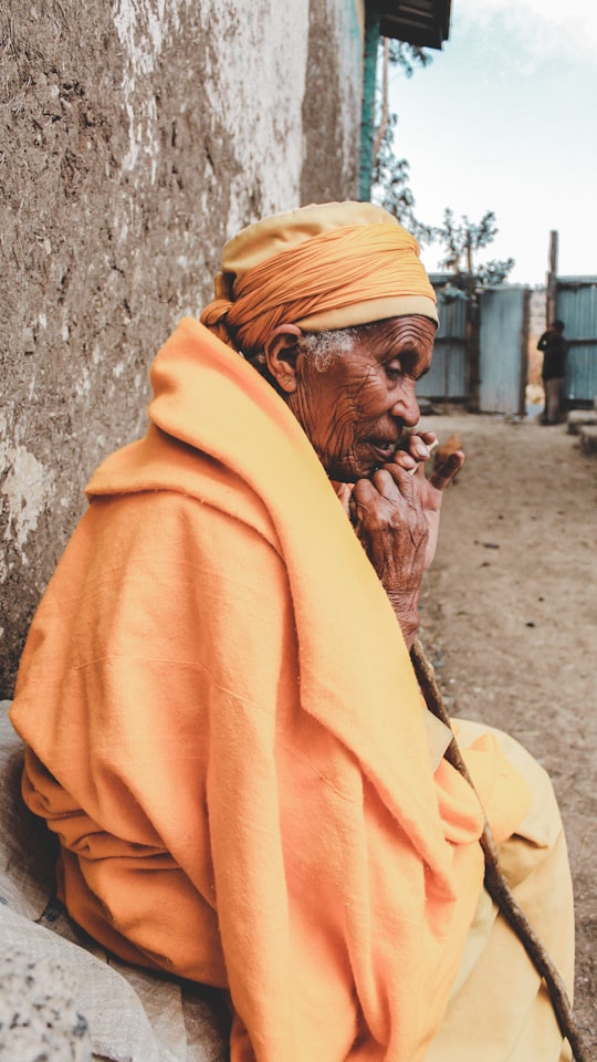 man in yellow hoodie leaning on wall in Debre Libanos Ethiopia