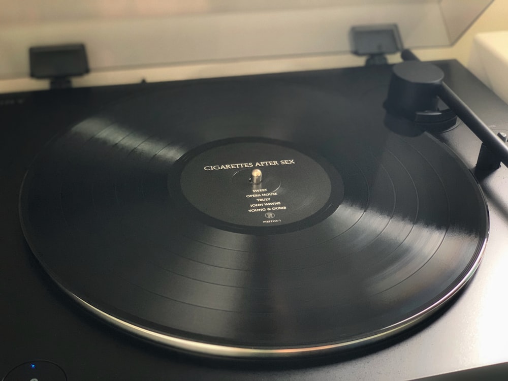 tourne-disque vinyle noir sur table blanche