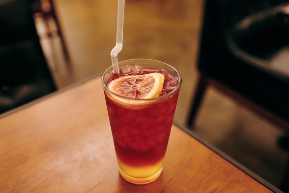 Vaso transparente con líquido naranja y hielo