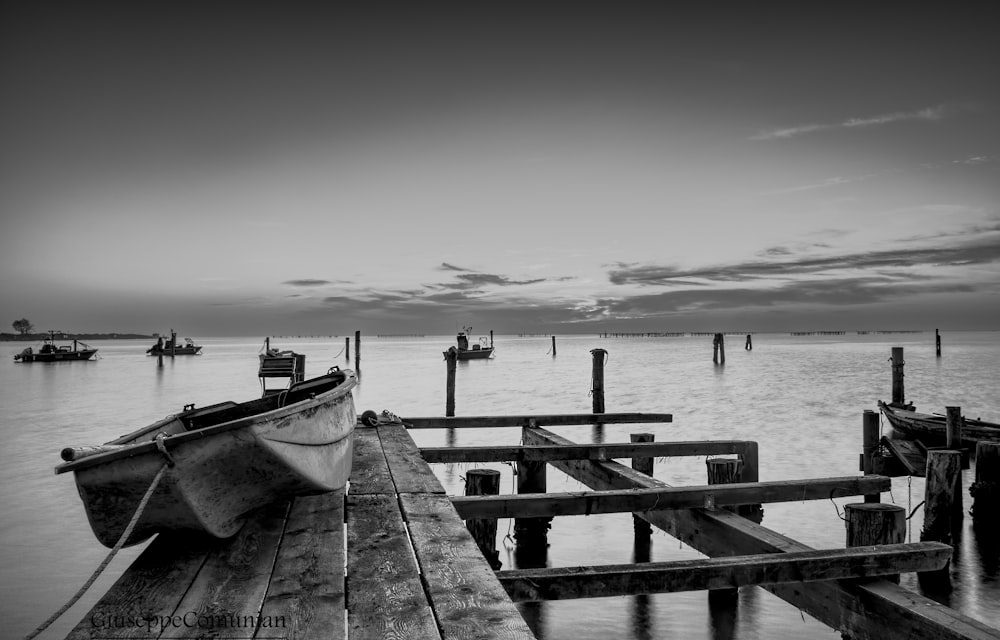 white and black boat on sea dock during daytime