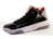 A high-top sneaker with a glossy black finish, featuring mesh panels and red accents on the interior lining. The shoe has a white midsole with a textured pattern and a translucent section on the heel. A distinctive logo is present on the side.