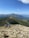 Group of hikers crossing a rocky mountain trail under a clear sky.