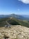 A group of hikers enjoying a scenic mountain trail under clear blue skies.
