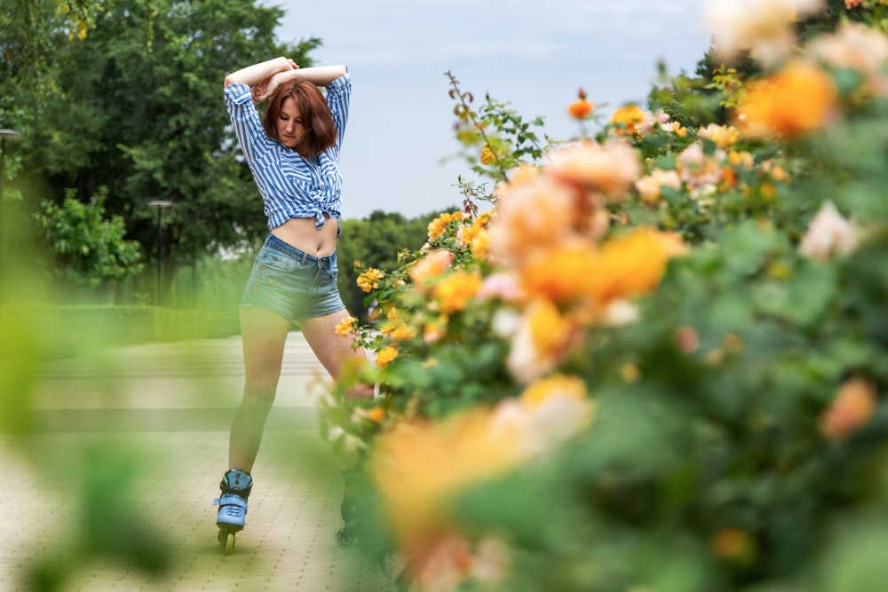 woman in black and white stripe shirt and blue denim shorts running on flower field during