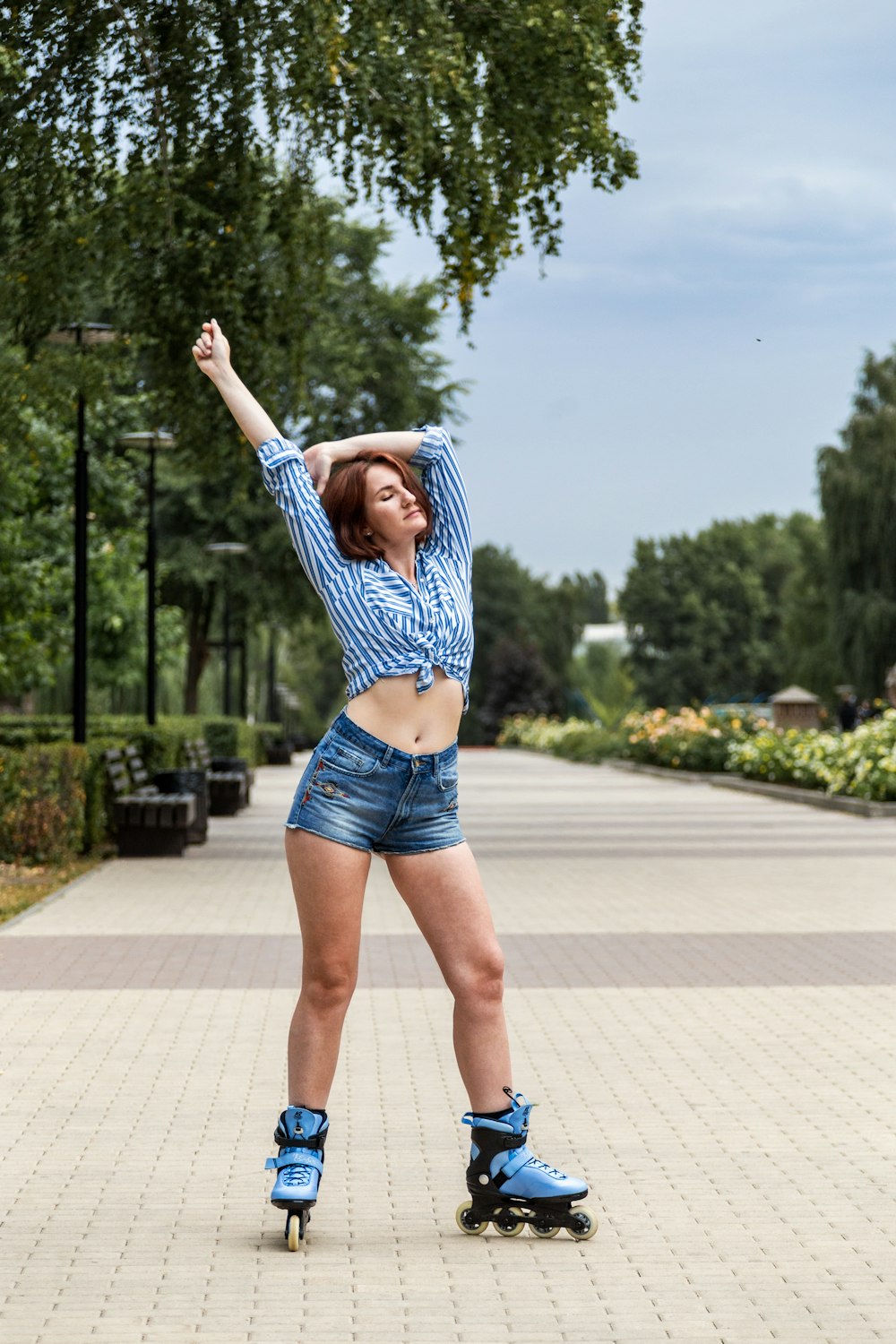 woman in blue and white striped long sleeve shirt and blue denim shorts standing on gray