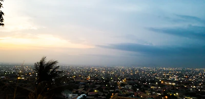 Accra spread out under a wide dusk sky, seen from above the city