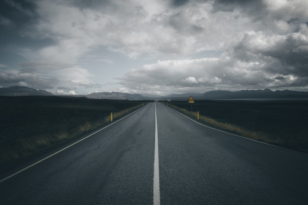 black asphalt road under gray cloudy sky during daytime