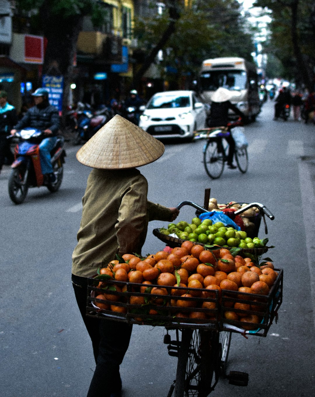 woman in brown long sleeve shirt carrying brown basket full of fruits