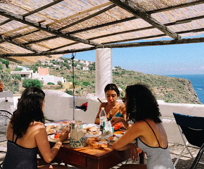 A group of women sharing a relaxed meal together, embodying joyful and mindful eating.