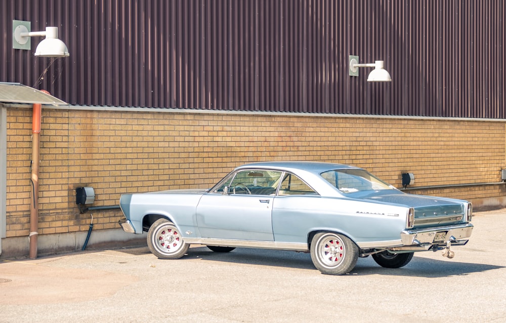 silver sedan parked beside brown brick wall