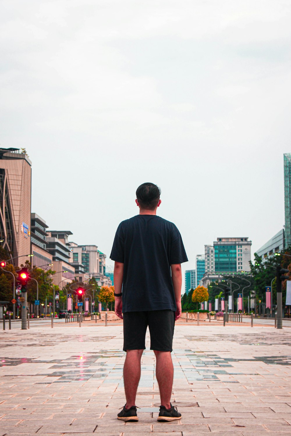 man in black long sleeve shirt standing on gray concrete floor during daytime