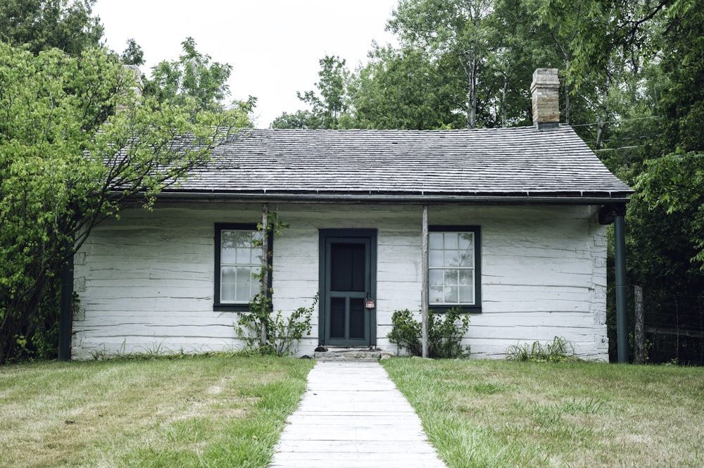 white wooden house with green grass lawn