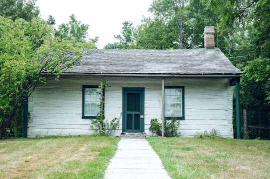 white wooden house with green grass lawn in Waterloo Region Museum Canada