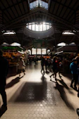 A photographer capturing a modern food market display with natural light filtering through.
