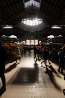 Photographer capturing a modern food market stall with natural light streaming in, showing fresh artisanal goods.